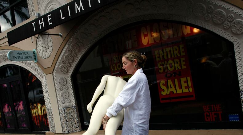 MIAMI - JANUARY 16: Marcie Ziv carries a Mannequin from The Limited store as it closes the location January 16, 2008 in Miami, Florida. Financial reports indicate that shoppers have tightened their belts on spending and manufacturers are seeing weak demand for cars and housing-related goods. (Photo by Joe Raedle/Getty Images)
