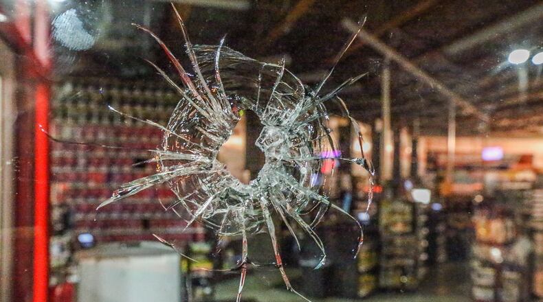 An AutoZone store was one of several businesses damaged by bullets when a gunman opened fire at two truck drivers and a police officer in a DeKalb County shopping center. JOHN SPINK / JSPINK@AJC.COM