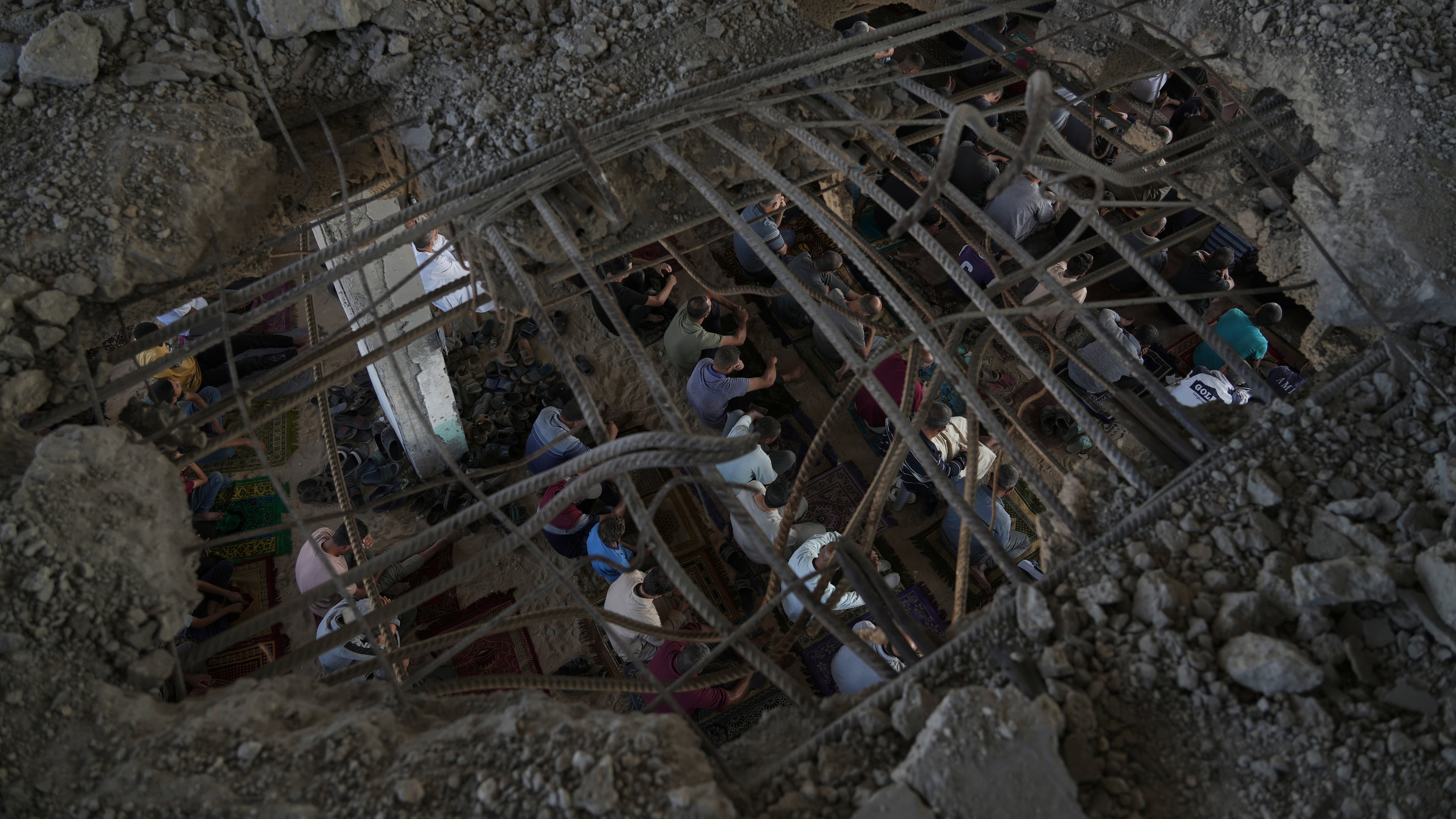 Palestinians gather for Friday prayers amid the rubble of a destroyed building in Khan Younis, in the southern Gaza Strip, Friday, Oct. 17, 2025. (AP Photo/Jehad Alshrafi)
