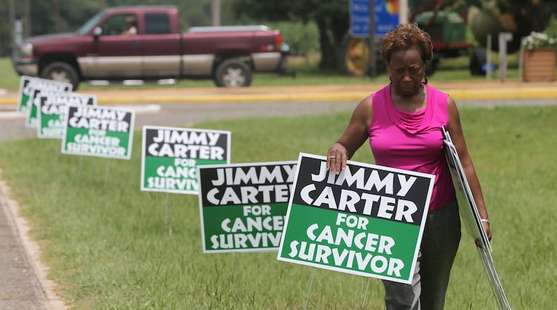 August 20, 2015 Plains, Ga: State Sen. Freddie Powell Sims (D-Dawson) places "Jimmy Carter for Cancer Survivor" signs along the road leading into Plains on Thursday afternoon August 20, 2015 in advance of the President's return to his hometown. Ben Gray / bgray@ajc.com
