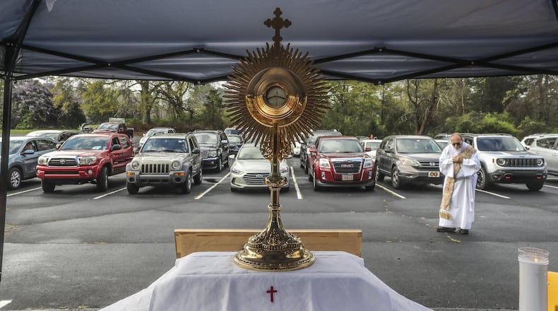 Deacon Fred Johns presided over “Drive-In” Adoration of the Most Blessed Sacrament in March. Some 50-cars attended in the parking lot at St. Pius X Catholic Church in Conyers. Since the COVID-19 outbreak, Catholics in the Atlanta Archdiocese and around the world have been implementing creative ways to serve the faithful. JOHN SPINK/JSPINK@AJC.COM