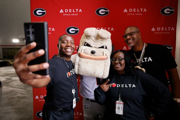 Delta maintenance worker Tommy O Whitfield (from left) takes a selfie with Kathy McCampbell and Patrick Maurice during the plane dedication ceremony for Hall of Famer and former UGA football coach Vince Dooley at Hartsfield-Jackson Atlanta International Airport. The airline is making a multimillion-dollar investment into UGA's hospitality program. (Miguel Martinez/AJC 2023)