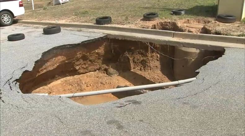 A sinkhole in the parking lot of CPS Auto Emission and Tires on Tara Boulevard is so big it scares away customers. (Credit: Channel 2 Action News)