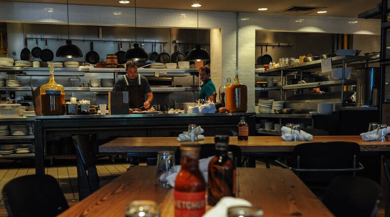 Chef Drew Van Leuvan puts the final touches on a dish before sending it out. 
Becky Stein for The Atlanta Journal-Constitution