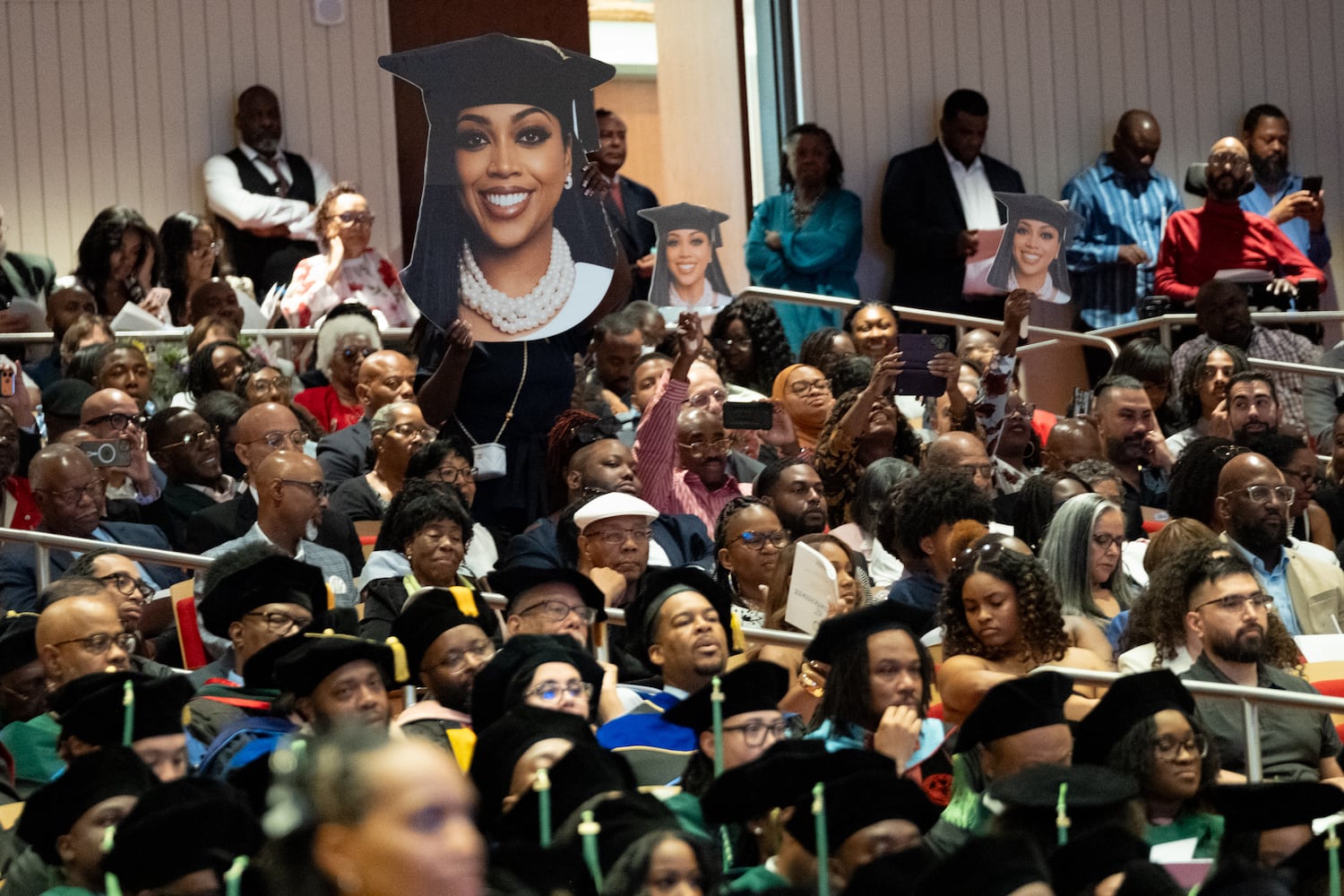 Family members hold up a student’s likeness as she receives her degree during the graduation ceremony for Morehouse School of Medicine on Saturday, May 16, 2026, in Atlanta. (Ben Gray for the AJC)