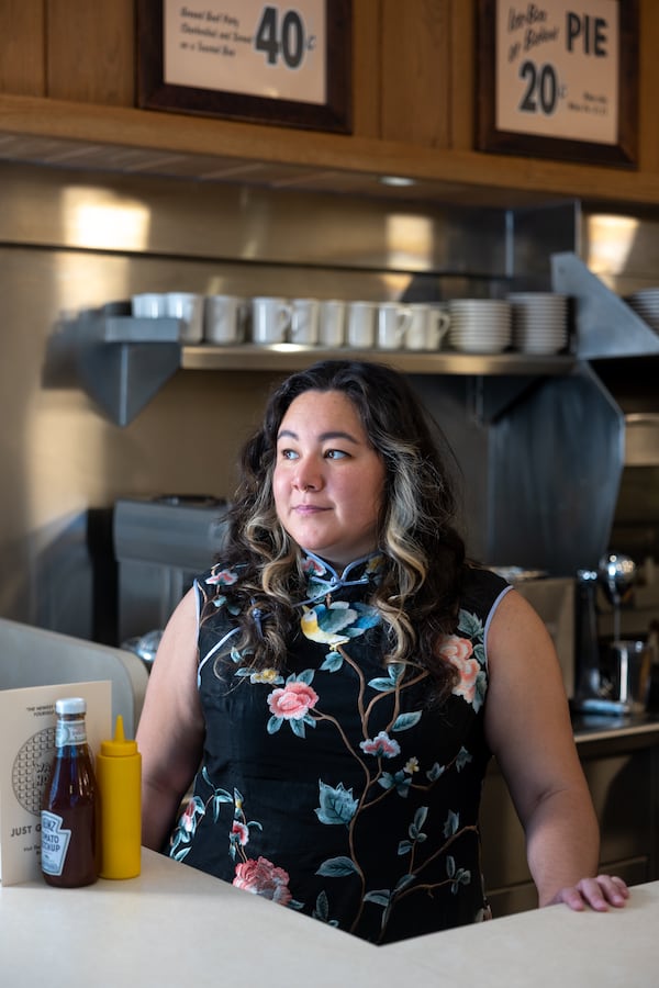 Emily Wu Pearson, 31, wears a qipao in a nod to her Taiwanese heritage, at the Waffle House Museum in Avondale Estates. (Arvin Temkar/AJC)