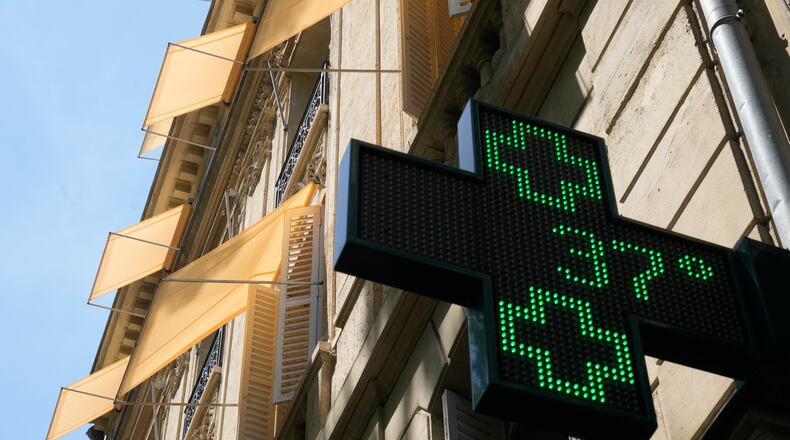A sign outside a pharmacy displays a temperature of 37 degrees Celsius (98.6 degrees Fahrenheit) in Paris, Sunday, June 21, 2026. (AP Photo/Michel Euler)
