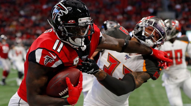 Falcons wide receiver Julio Jones stiff arms Tampa Bay's Carlton Davis after a reception in the first half Sunday, Nov. 24, 2019, at Mercedes-Benz Stadium in Atlanta.