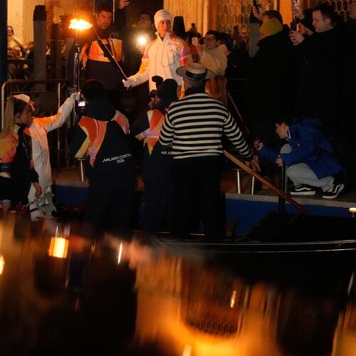 Torchbearers hold the Olympic torches flame on the Grand Canal in Venice, Italy, Thursday, Jan. 22, 2026, its journey will conclude in Milan on February 6 for the Winter Olympics opening ceremony. (AP Photo/Luca Bruno)
