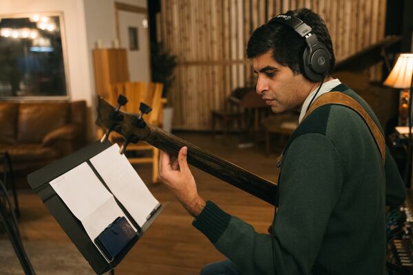 Kabir Sehgal plays bass during a recording session at Tree Sound Studios. (Olivia Bowdoin/AJC)