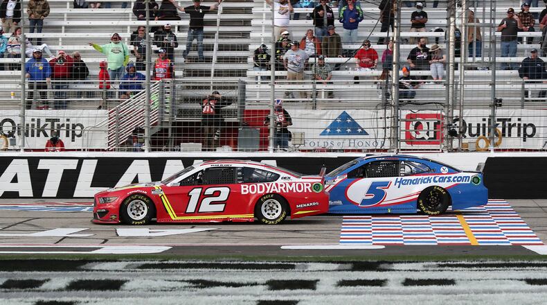 Ryan Blaney in the No. 12 car passes Kyle Larson with eight laps remaining on his way to winning the Atlanta Motor Speedway Folds of Honor QuickTrip 500 on Sunday, March 21, 2021, in Hampton, Georgia. (Curtis Compton/Atlanta Journal-Constitution/TNS)