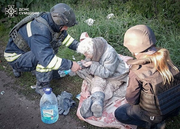 In this photo provided by the Ukrainian Emergency Services on May 8, 2025, a rescue worker helps an injured elderly woman evacuated from a building which was heavily damaged by a Russian strike in Sumy region, Ukraine. (Ukrainian Emergency Service via AP)