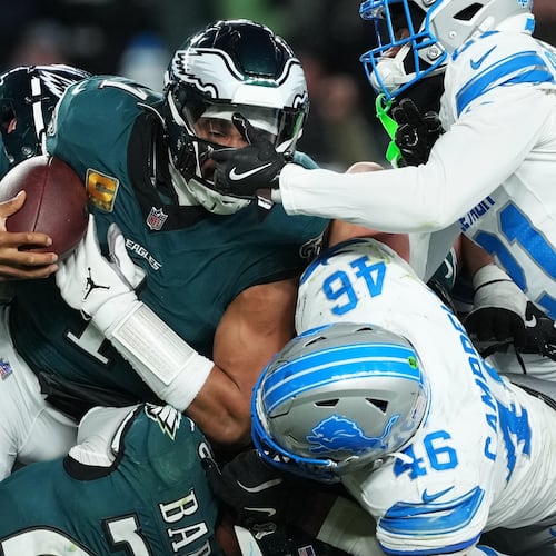 Philadelphia Eagles quarterback Jalen Hurts (1) is stopped with the ball during the second half of an NFL football game by Detroit Lions linebacker Jack Campbell (46) and Lions cornerback Amik Robertson (21) Sunday, Nov. 16, 2025, in Philadelphia. (AP Photo/Matt Slocum)