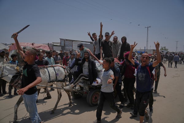 Palestinians carry bags containing food and humanitarian aid packages delivered by the Gaza Humanitarian Foundation, a U.S.-backed organization, in Rafah, southern Gaza Strip, Sunday, June 8, 2025. (AP Photo/Abdel Kareem Hana)