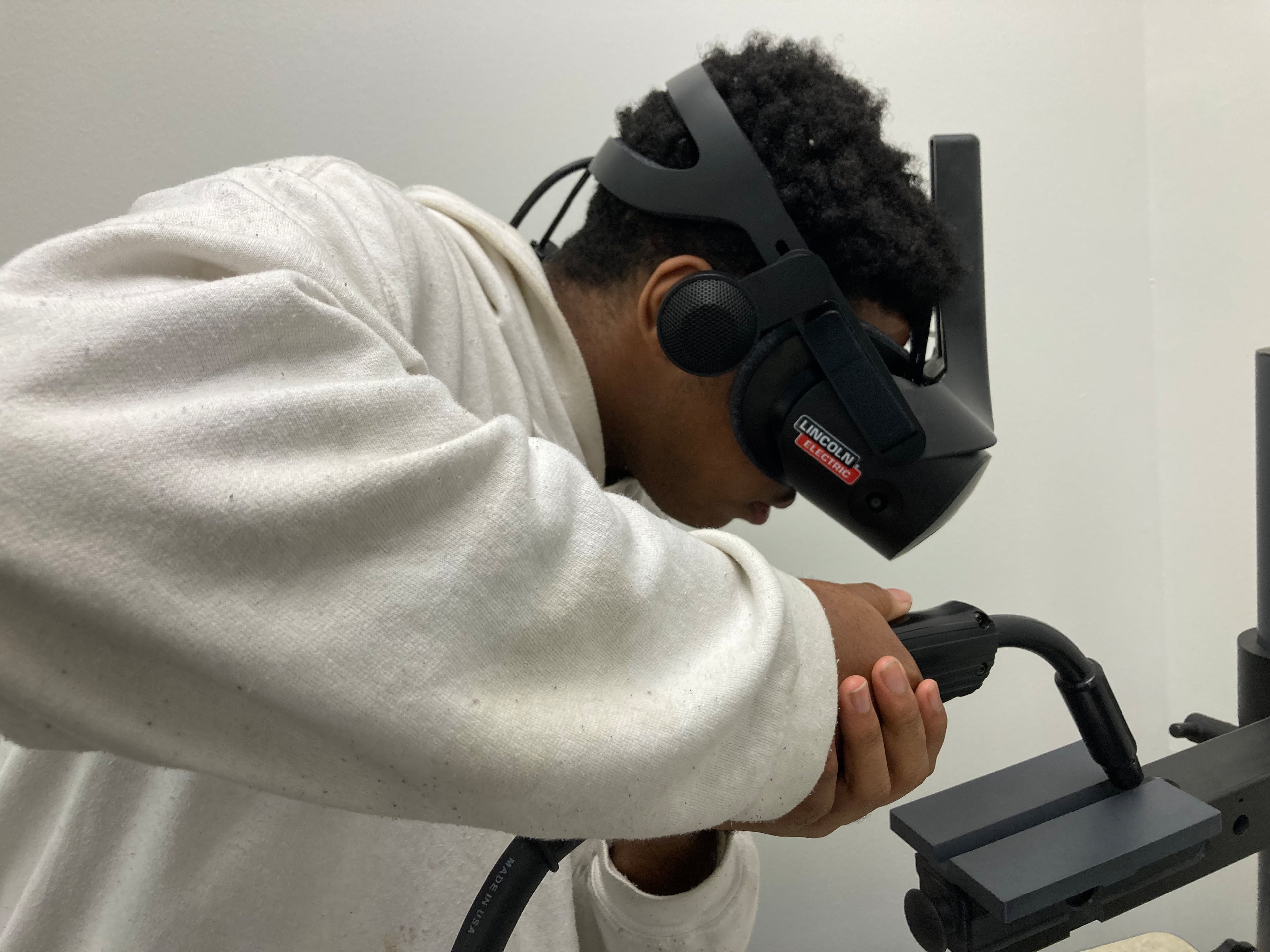 Dorien McConnehead uses a virtual reality simulator to learn welding skills at the Woodstock career center run by Goodwill of North Georgia. He sees sparks, hears sizzle and feels resistance, but it's all computer generated. (AJC 2024)