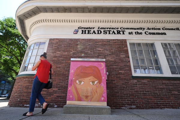 A woman walks toward the Greater Lawrence Community Action Council office where immigrants receive health assistance, June 25, 2025, in Lawrence, Mass. (AP Photo/Charles Krupa)