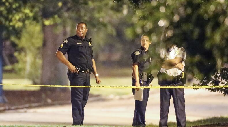 Police investigate a body found in Piedmont Park. JOHN SPINK / JSPINK@AJC.COM