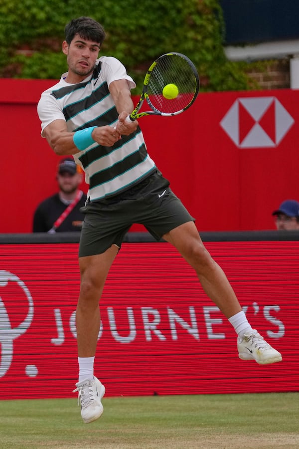 Carlos Alcaraz of Spain leaps as he plays a return to Jiri Lehecka of the Czech Republic, during the men's singles final of the Queens Club tennis championships in London, Sunday, June 22, 2025. (AP Photo/Joanna Chan)