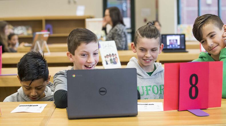 Buford Senior Academy students Ryan Robertson, left, Hayden Shepheard and Joshua Young, right, react as they watch a music video featuring music artist Lil Nas X during a Black History Month music themed event at their school’s library on Monday, Feb. 10, 2020. ALYSSA POINTER/ALYSSA.POINTER@AJC.COM