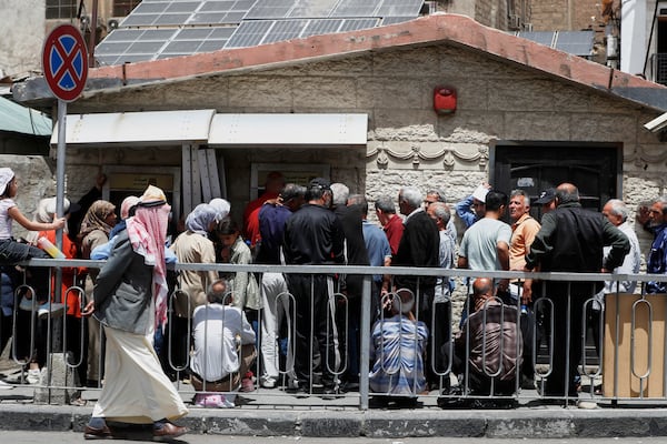 Syrians line up to retrieve money from an ATM in Damascus, Syria, Wednesday, May 14, 2025. (AP Photo/Omar Sanadiki)