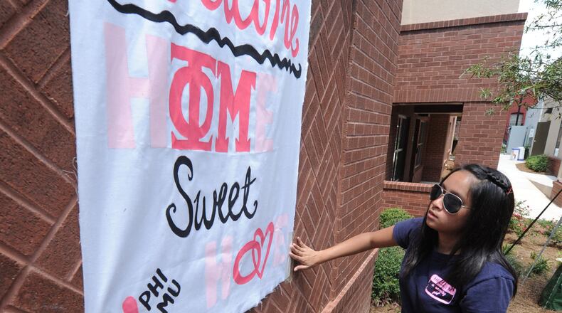 100812- Atlanta - Umama Kibria puts up a welcome sign for her Phi Mu sisters on Thursday AUG 12, 2010. Students moved into the new Special Interest Student House at Georgia State today. This is the Greek housing for the frats and sororities. It is nine three-story town homes with 139 beds at the corner of Edgewood and Piedmont. Nine of the 24 Greek organizations are moving in. The sororities that will live in Greek Housing this year are Alpha Omicron Pi, Alpha Xi Delta, Delta Zeta, Phi Mu and Zeta Tau Alpha. The fraternities are Kappa Sigma, Phi Beta Sigma, Pi Kappa Phi and Sigma Nu. JohnnyCrawford,Jcrawford@ajc.com