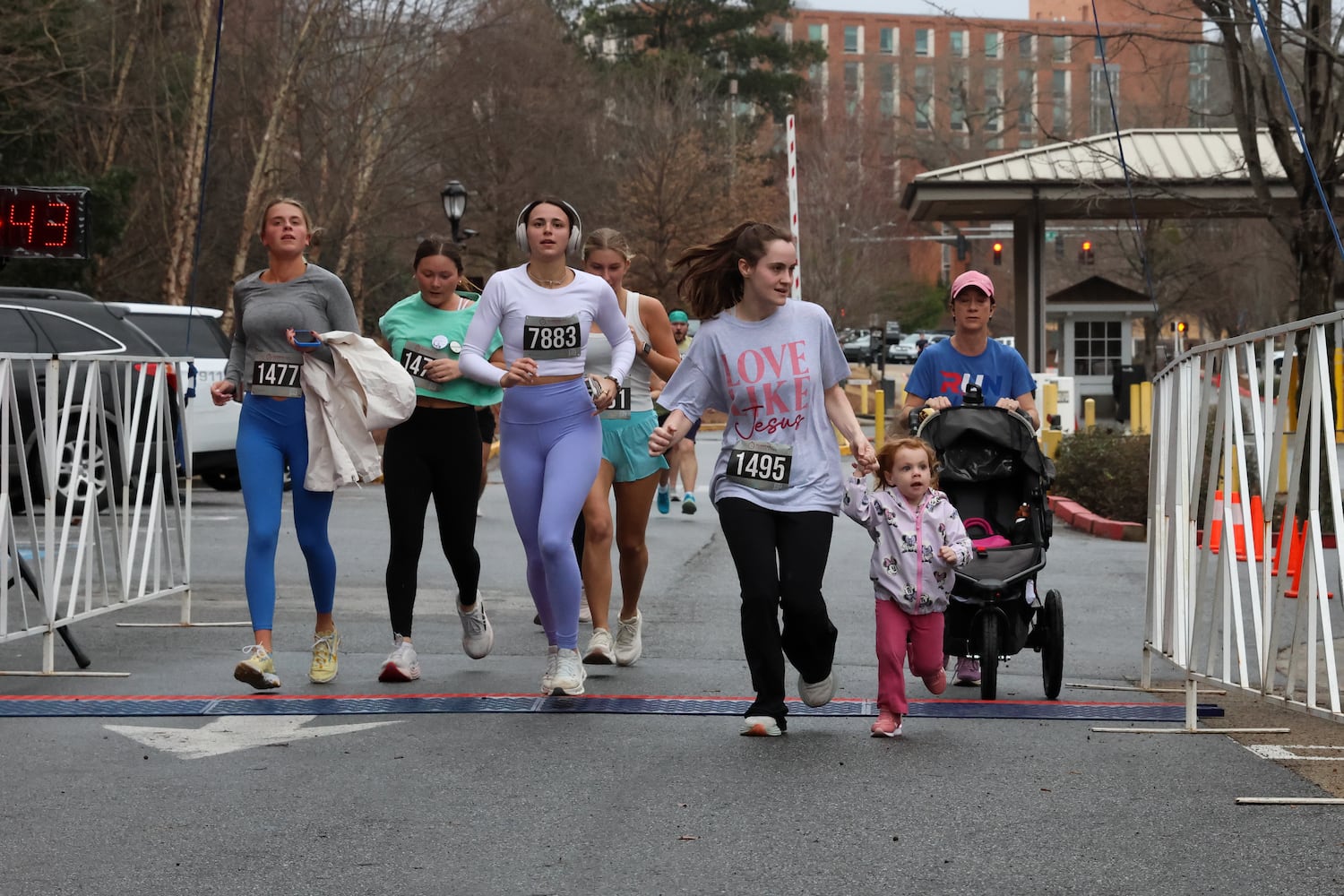 Runners cross the finish line on Saturday, Feb. 21, 2026, at a 5K walk/run and memorial service at UGA for Augusta University nursing student Laken Riley. Riley was attacked on Feb. 22, 2024 while running in Oconee Forest Park on the UGA campus and killed. Riley had previously attended UGA and was an avid runner. (C.J. Bartunek for the AJC)

