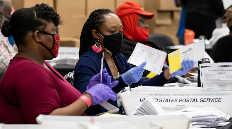 Workers sort mail-in and drop-off ballots at the Fulton County sorting center at State Farm Arena on Tuesday evening, Nov. 3, 2020, just before polls closed. (Ben Gray for the AJC)
