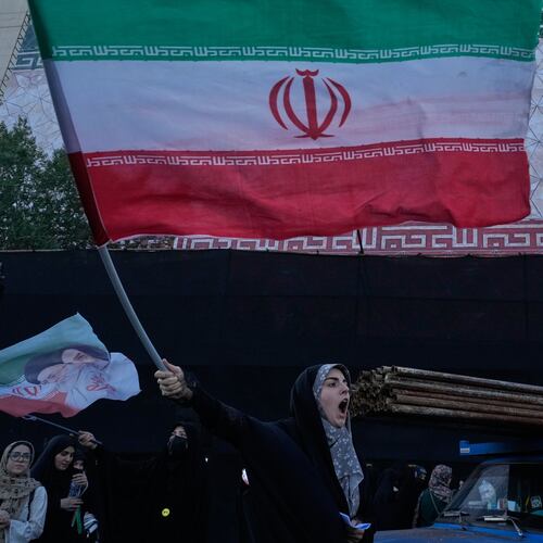 A woman waves an Iranian flags as she chants slogans against Iran and U.S. talks at the Islamic Revolution square in Tehran, Iran, Sunday, June 14, 2026. (AP Photo/Vahid Salemi)