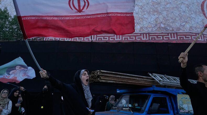A woman waves an Iranian flags as she chants slogans against Iran and U.S. talks at the Islamic Revolution square in Tehran, Iran, Sunday, June 14, 2026. (AP Photo/Vahid Salemi)