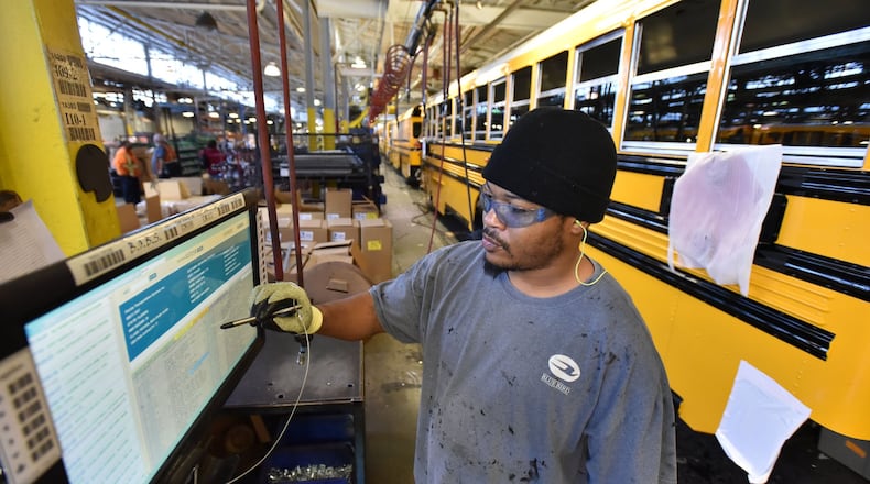 Worker checks his screen naer the Blue Bird assembly line in Fort Valley. The company makes more than 11,000 buses a year and employs 2,400. (Photo: HYOSUB SHIN / HSHIN@AJC.COM)