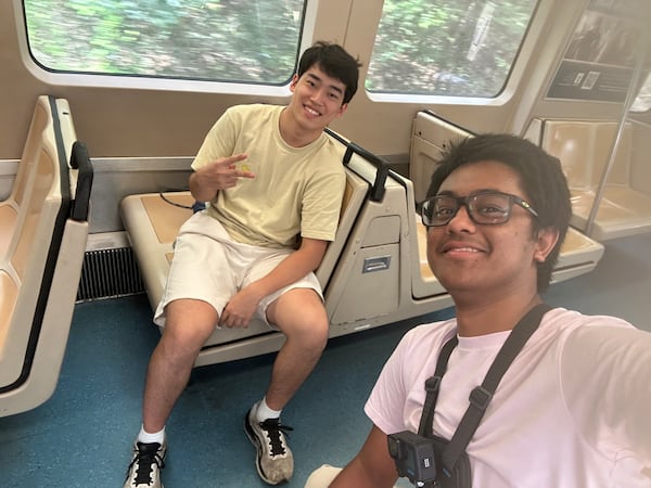 Andrew Zhang (left) and Ayush Maini pose on a MARTA train in the middle of their attempt to visit all train stations in record time. Guinness World Records has to confirm their time to make a record official. (Courtesy of Ayush Maini)