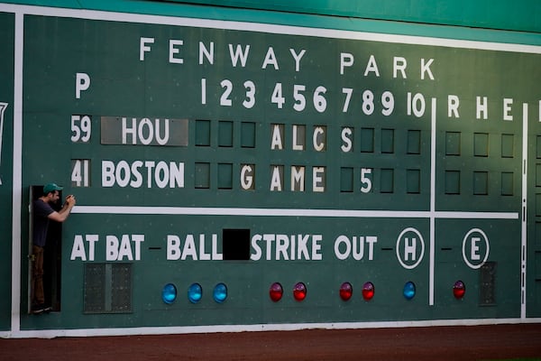 A scoreboard worker takes a picture before a game in this Oct. 20, 2021 file photo, in Boston. (AP Photo/Robert F. Bukaty)