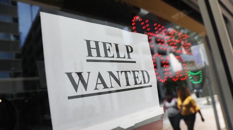 A “help wanted” sign hangs on a window of a restaurant earlier this month. Metro Atlanta’s jobless rate has slid to a 17-year low. (Photo by Joe Raedle/Getty Images)