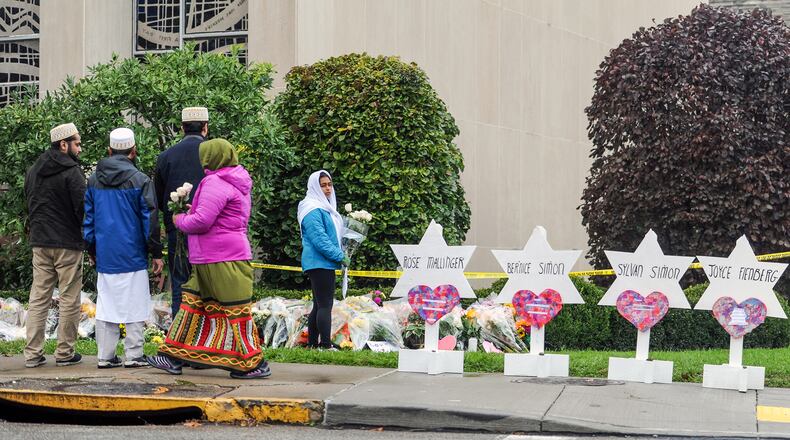 Members of Pittsburgh's Dawoodi Bohra Muslim community place flowers at the memorial in front of the Tree of Life synagogue, Sunday, Oct. 28, 2018, in the Squirrel Hill neighborhood of Pittsburgh. (Pittsburgh Post-Gazette/TNS)
