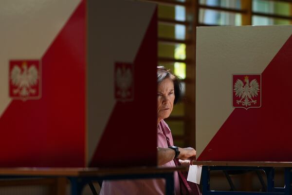 A women prepares to cast her vote during the presidential election runoff in Warsaw, Poland, Sunday, June 1, 2025. (AP Photo/Petr David Josek)
