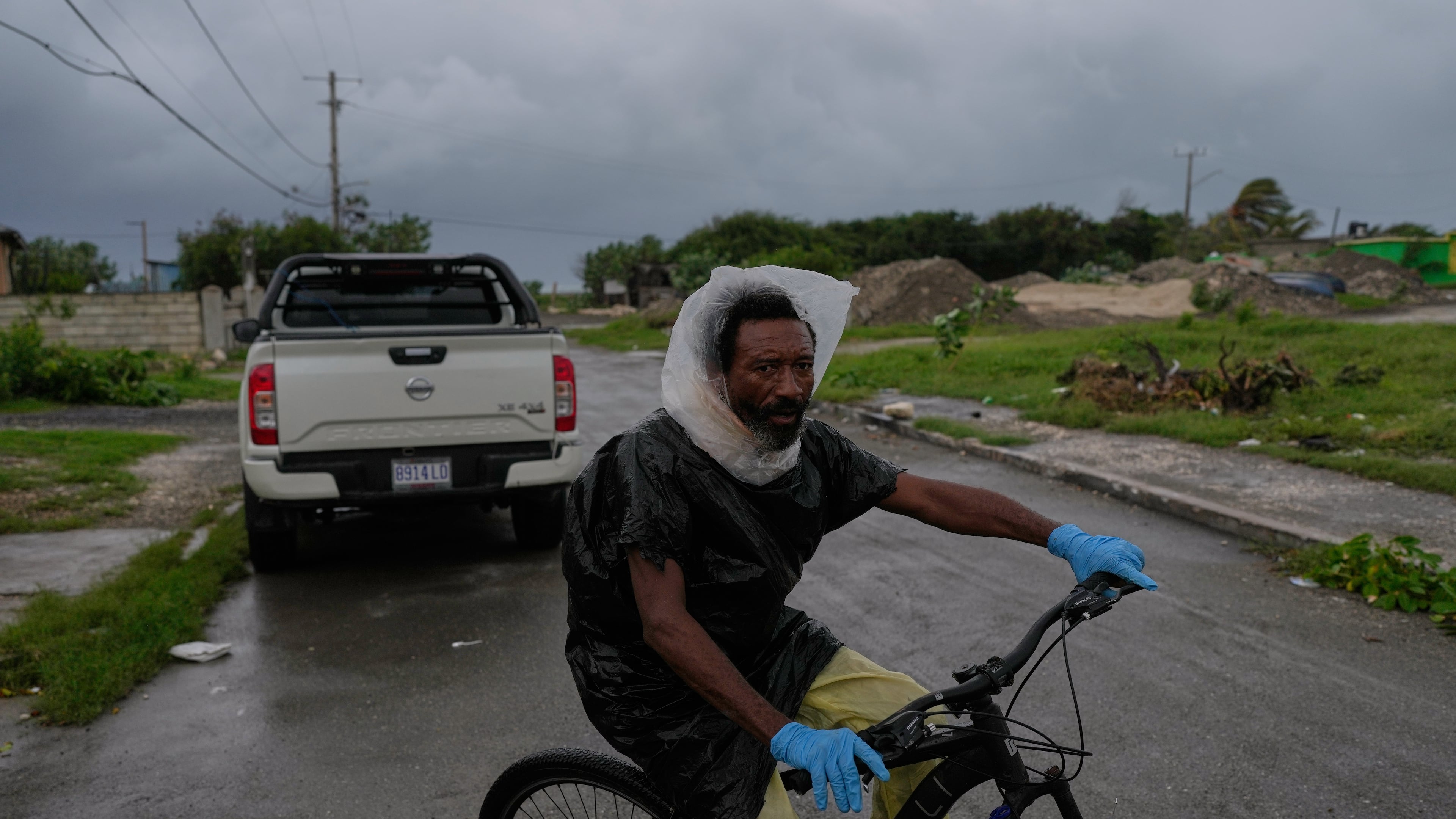 A man rides a bicycle ahead of the forecast arrival of Hurricane Melissa in Kingston, Jamaica, Sunday, Oct. 26, 2025. (AP Photo/Matias Delacroix)
