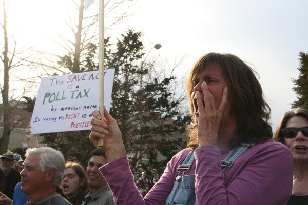 A protester holds a sign outside a town hall holds by Rep. Chuck Edwards in Asheville, N.C. on Thursday, March 13, 2025. (AP Photo/Makiya Seminera)