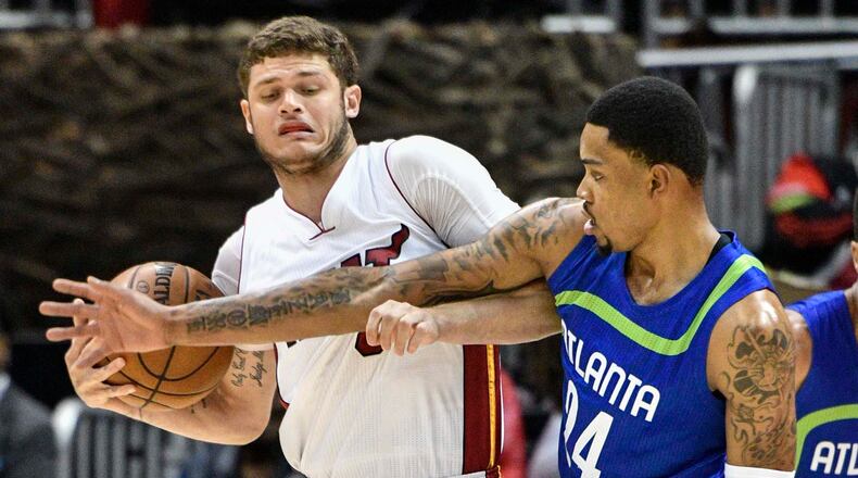 Miami Heat guard Tyler Johnson tries to keep Atlanta Hawks forward Kent Bazemore, right, from the ball during the first half of an NBA basketball game, Friday, Feb. 24, 2017, in Atlanta. (AP Photo/John Amis)