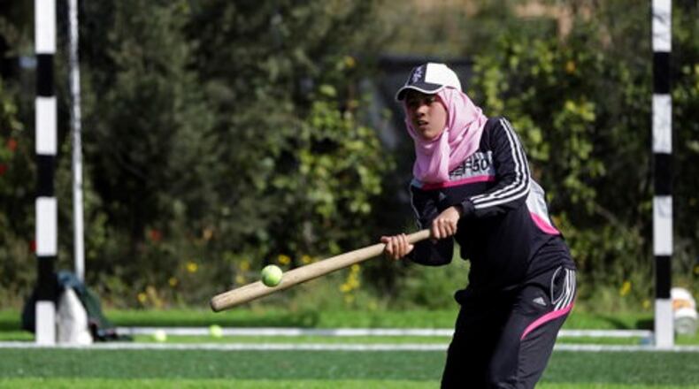 In this Sunday, March 19, 2017 photo, Palestinian women train for an all women's baseball game, on a soccer field in Khan Younis, southern Gaza Strip. The female players wear hijabs, not helmets, toss around tennis balls, not baseballs and their leather gloves have been replaced by black imitations knitted from fabric. The group of young women are trying to bring baseball to Gaza -- giving the traditional American pastime a distinctly local feel. (AP Photo/Khalil Hamra)