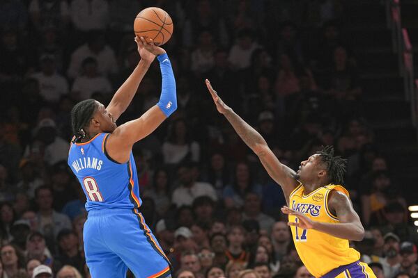 Oklahoma City Thunder forward Jalen Williams, left, shoots over Los Angeles Lakers forward Dorian Finney-Smith, right, during the first half of an NBA basketball game, Tuesday, April 8, 2025, in Oklahoma City. (AP Photo/Kyle Phillips)