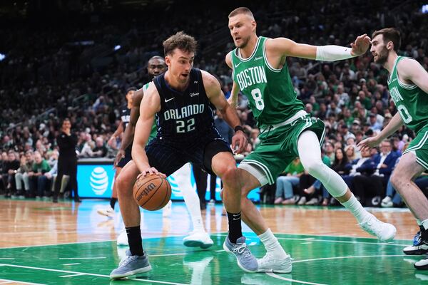 Orlando Magic forward Franz Wagner (22) drives to the basket against Boston Celtics center Kristaps Porzingis (8) during the first half in game 2 of a first-round NBA playoff basketball series, Wednesday, April 23, 2025, in Boston. (AP Photo/Charles Krupa)