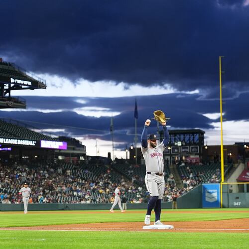 Houston Astros first baseman Christian Walker stretches as he takes his position while clouds roll in over Coors Field in the fourth inning of a baseball game against the Colorado Rockies Tuesday, April 7, 2026, in Denver. (AP Photo/David Zalubowski)