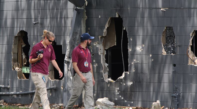 Law enforcement personnel investigate on the west side of Pulse nightclub where a gunman opened fire on Sunday morning, June 12, 2016, in Orlando, Fla. The gunman, wielding an assault-type rifle and a handgun, opened fire inside a crowded gay nightclub early Sunday, before dying in a gunfight with SWAT officers, police said. It was the worst mass shooting in American history. (Doug Clifford/The Tampa Bay Times via AP)