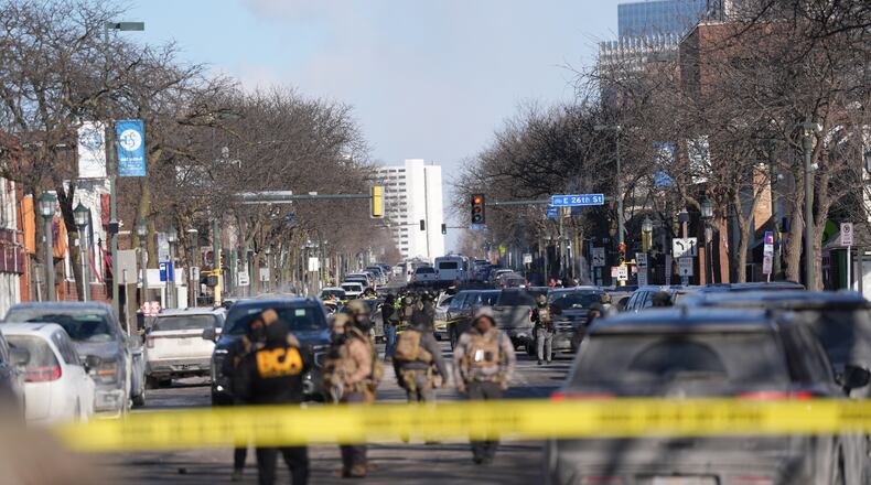 Federal agents stand near the site of a shooting Saturday, Jan. 24, 2026, in Minneapolis. (AP Photo/Abbie Parr)
