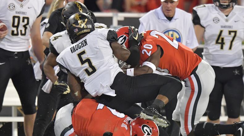 October 6, 2018 Athens - Vanderbilt running back Ke'Shawn Vaughn (5) gets tackled by Georgia defensive back Richard LeCounte (2) and Georgia defensive back J.R. Reed (20) in the first half during a NCAA college football game at Sanford Stadium in Athens on Saturday, October 6, 2018. HYOSUB SHIN / HSHIN@AJC.COM