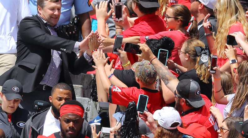 Kirby Smart high-fives some fans while others film his entry into Sanford Stadium Saturday for Georgia's G-Day game.