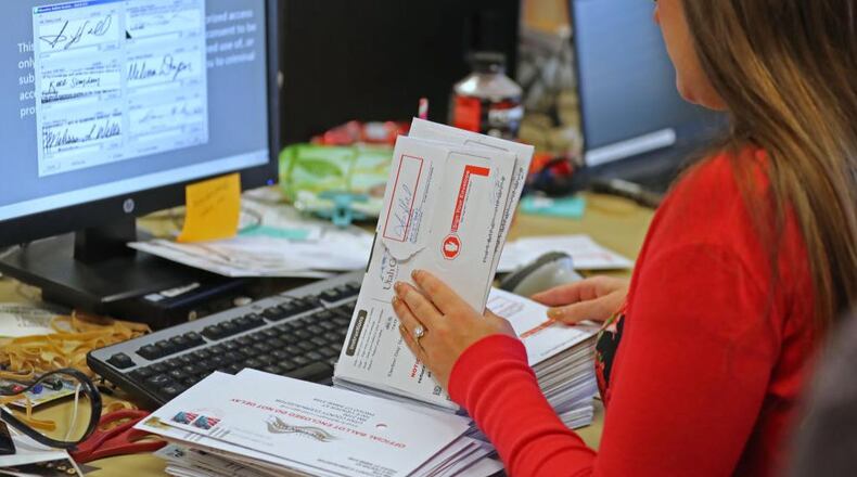 An election worker verifies signatures on mail-in ballots for the midterm elections on November 6, 2018.