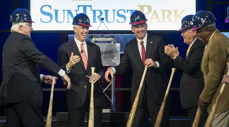 Cobb County Chairman Tim Lee, left, Atlanta Braves chairman Terry McGuirk, second from left, SunTrust CEO William Rogers, third from left, Georgia Gov. Nathan Deal, second from right, and Hall of Fame baseball player Hank Aaron, right, wrap up a ground-breaking ceremony for the Atlanta Braves new baseball stadium, which will be called SuntTust Park.