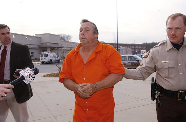Carl M. Patton, Jr., 53, in orange jumpsuit, was convicted of four 1977 murders. He is escorted by Fayette County Sheriff's Corporal Jimmy Gunn, right. He was also the father of Melissa Wolfenbarger. (Kimberly Smith/AJC staff 2003)