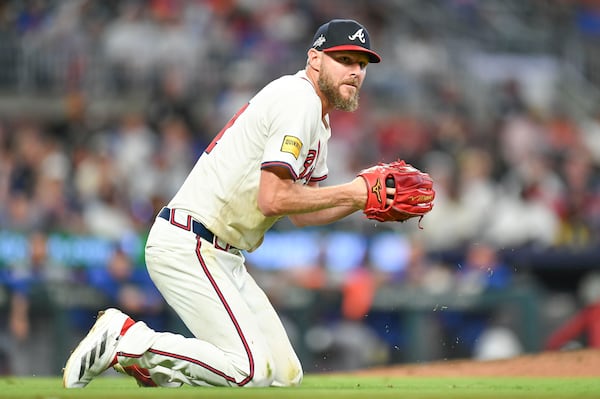 Braves pitcher Chris Sale gets to his knees after diving for a ball (and hurting his ribs) in the ninth inning of a win over the Mets. 
